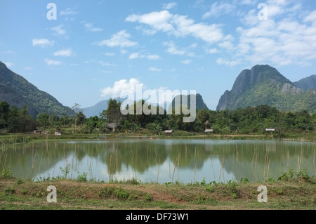 Mountain scenery reflected on a pond near Vang Vieng, Laos Stock Photo