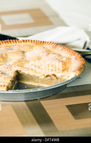 Freshly baked apple pie in a tin with a slice taken out. Stock Photo