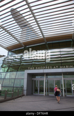 The Shoppes Marina Bay Sands Hotel Singapore shopping center entrance shop shops trade couple enter daylight in buy trade Stock Photo