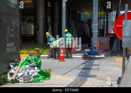 Construction workers Singapore street Asia three progress works public green equipment repair damage make red cone carry Stock Photo