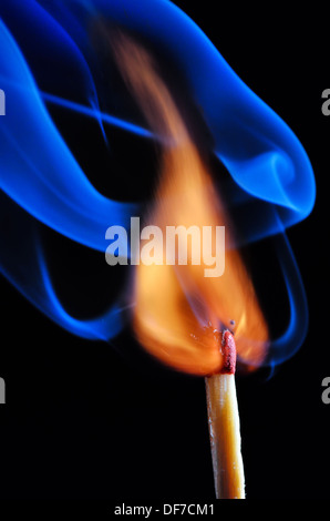 Burning match with blue smoke on black background Stock Photo
