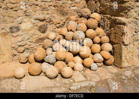 Canon balls stored alongside a wall at the ancient city of Aptera in western Crete. Stock Photo