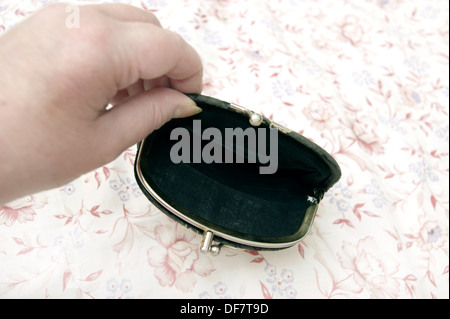 Woman holding an empty purse (a sign of the times in the age of austerity) Stock Photo