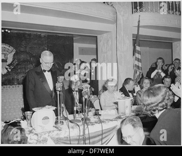 President Harry S. Truman is standing at a microphone during a dinner event at the Mayflower Hotel in Washington, D.C., honoring him and Vice President Alben Barkley. Stock Photo