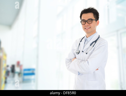 Asian male medical doctor with confident smile standing inside hospital building. Stock Photo
