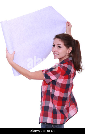 Young woman unrolling wallpaper Stock Photo