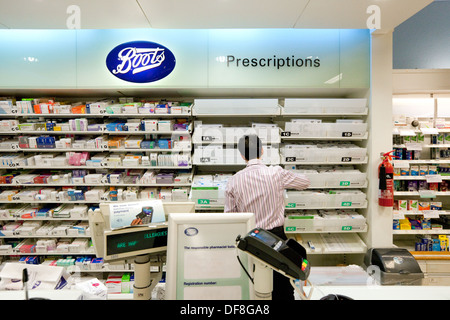 Pharmacy counter; UK Pharmacy interior; Boots the Chemist, the pharmacist working in the pharmacy, UK. Uk worker example. Stock Photo