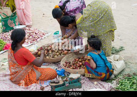 Indian girl amongst mothers buying vegetables from a street market. Puttaparthi, Andhra Pradesh, India Stock Photo