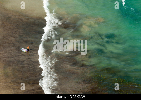 Aerial view of boy with air mattress entering the sea in Benidorm, Spain Stock Photo