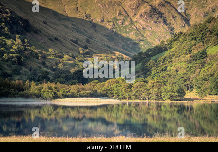 Looking across a reflective Brothers Water toward Hartsop above How, Cora Crag, Gale Crag and Hoggill Brow in the Lake District. Stock Photo