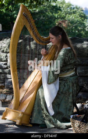 New York City USA Sept 29th 2013. Medieval Festival at Fort Tryon Park. Woman playing the Harp in Renaissance Dress at the Medieval Festival in Fort Tryon Park in the Inwood neighborhood of NYC. Credit:  Anthony Pleva/Alamy Live News Stock Photo