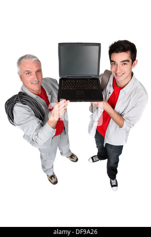 Two men showing a laptop computer Stock Photo