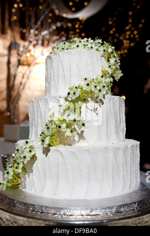 A three-tiered wedding cake decorated with flowers. Stock Photo