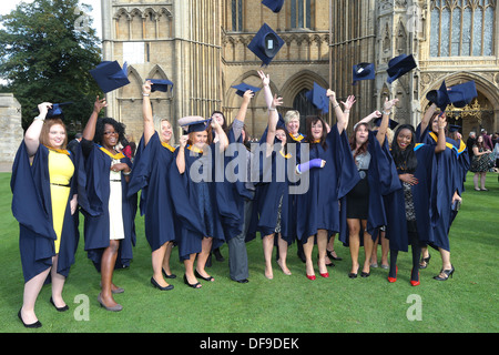 Happy graduating students throwing graduation  caps 