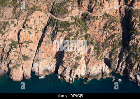 AERIAL VIEW. Vertiginous road, a dizzying 145-meter-high above the Mediterranean Sea. Gulf of Porto. Corsica, France. Stock Photo