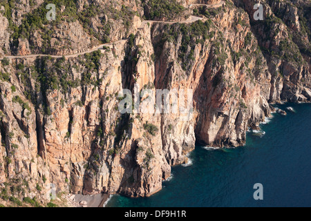 AERIAL VIEW. Vertiginous road, a dizzying 145-meter-high above the Mediterranean Sea. Gulf of Porto. Corsica, France. Stock Photo