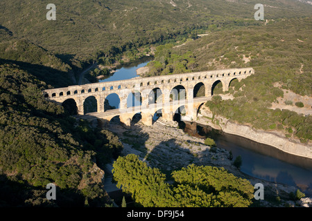 AERIAL VIEW. Roman aqueduct bridge over the Gard (aka Gardon) River. On the UNESCO world heritage list. Pont du Gard, Occitanie, France. Stock Photo