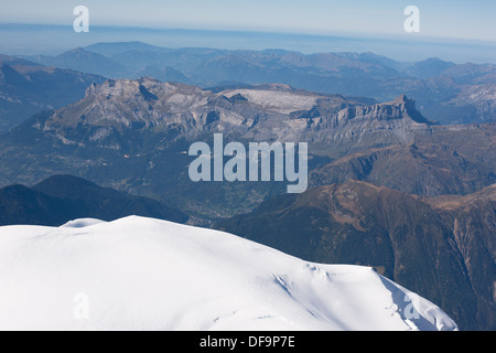 AERIAL VIEW. Snow-capped Dome du Goûter (4304m) and Désert de Platé (pale limestone in the distance). Les Houches, Auvergne-Rhône-Alpes, France. Stock Photo