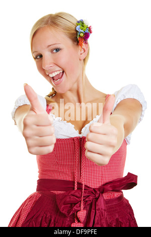 Happy young woman in a dirndl holding both thumbs up Stock Photo