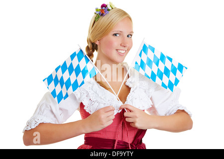 Smiling woman in a dirndl with two small bavarian flags Stock Photo