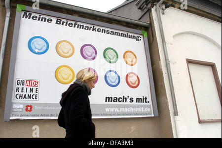 A young woman walks past an advertisement poster which asks people to use condoms to prevent AIDS on the 9th of February in 2005. Stock Photo