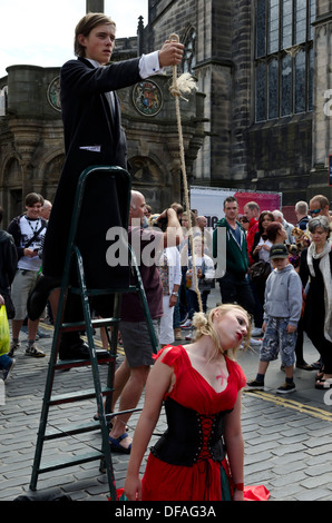 Theatre group promoting their show (woman being hung) during the Festival Fringe in the Royal Mile, Edinburgh, Scotland. Stock Photo