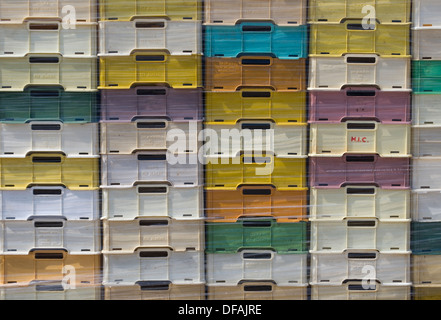 Stacked colored fish plastic boxes wrapped in polythene Stock Photo