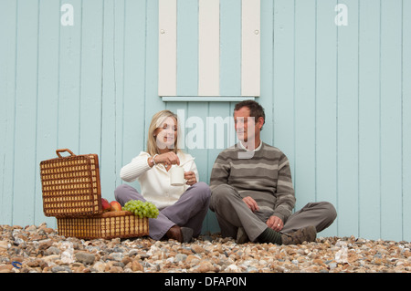 middle aged couple enjoying a picnic on the beach Stock Photo