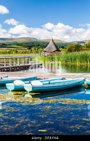 Rowing boats moored at Llangors Lake in the Brecon Beacons National Park, Wales with the crannog beyond. Stock Photo