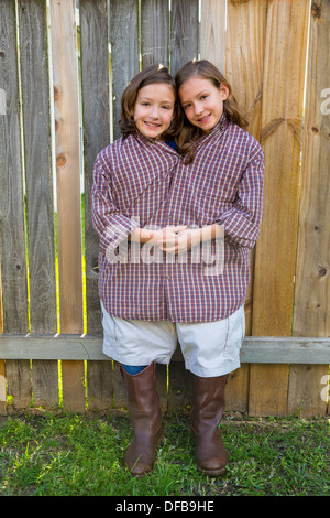 twin girls fancy dressed up pretending be siamese with his father shirt Stock Photo