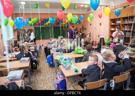 Small students sitting in decorated classroom at the first lesson in Russian elementary school, Russia Stock Photo