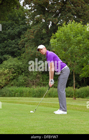 Photo of a golfer addressing the ball and playing a wedge shot into the green. Series of five in the set. Stock Photo