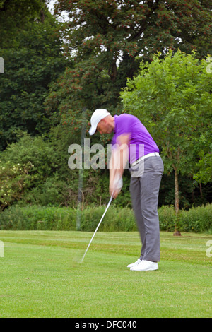 Photo of a golfer addressing the ball and playing a wedge shot into the green. Series of five in the set. Stock Photo