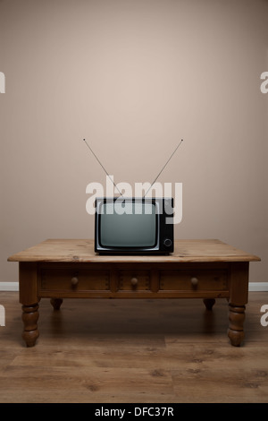 An old retro TV on a table with blank screen in an empty room Stock Photo