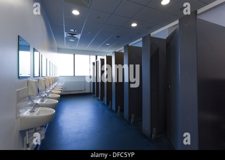 Unoccupied female public toilets with wash basins and cubicles. Stock Photo