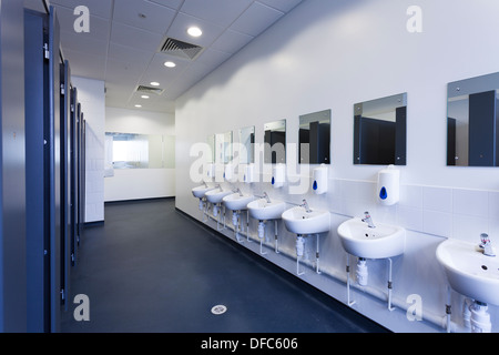 Unoccupied female public toilets with wash basins and mirrors. Stock Photo