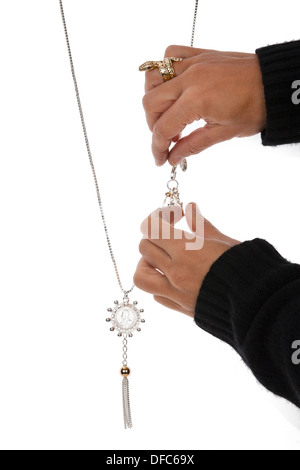 Womans hand positioning jewellery chain against white background. Stock Photo
