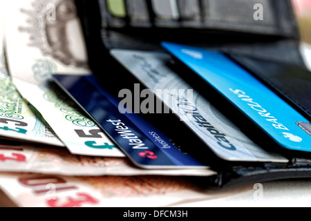 Close up of Debit Credit Bank cards Natwest Barclays Capital One in a leather wallet and bank notes UK Stock Photo