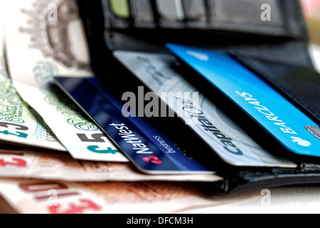 Close up of open leather wallet showing English British bank notes banknotes cash money and bank debit credit card cards England UK United Kingdom Stock Photo