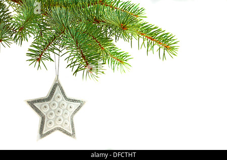 Silver star Christmas tree ornament hanging from a pine tree Stock Photo