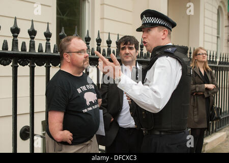London, UK. 2nd October 2013. Police officer liaises with Nick Doberick (Thalidomide Trust) centre, outside the German consulate in Belgrave Square, highlighting the German government's protection of the pharmaceutical company Grünenthal from legal action by UK Thalidomide victims. London UK, 2nd October 2013. Credit:  martyn wheatley/Alamy Live News Stock Photo