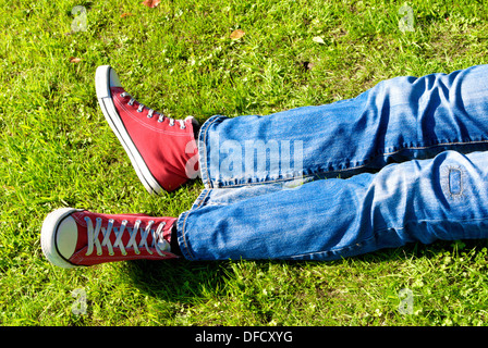 Legs of a young man relaxing on grass Stock Photo