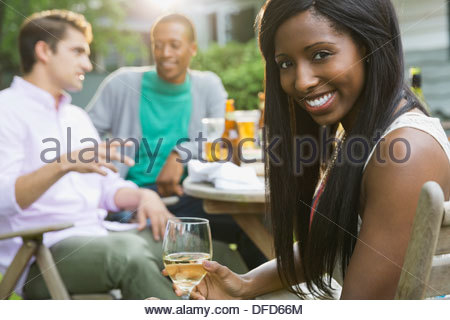 Portrait of happy woman with friends at outdoor dining table