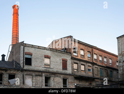 Old abandoned industrial buildings and tall chimney Stock Photo