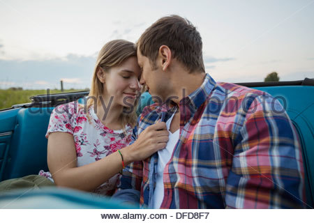 Affectionate young couple sitting in convertible