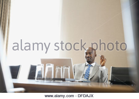 Businessman looking at laptop in hotel conference room