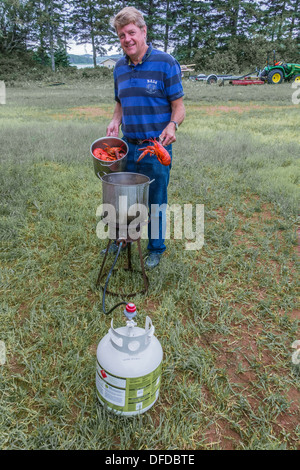 A Canadian man preparing lobsters in a boiling pot outside on Prince Edward Island, Canada. Stock Photo