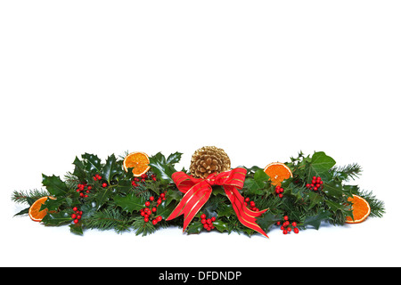 A traditional Christmas garland made from fresh holly with red berries, dried orange segments, green ivy, fresh conifer sprigs Stock Photo
