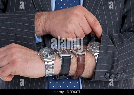 Businessman with four wrist watches checking the time. Good image for time related themes. Stock Photo