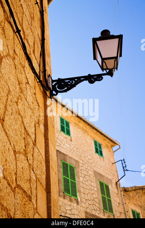 Street in Valldemossa, Majorca, Spain with ornate street lamp and house with green shutters. Stock Photo